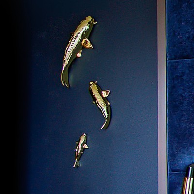 Gold koi sculptures mounted on the navy headboard wall