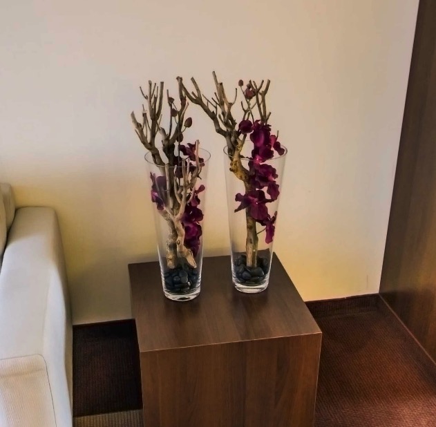 Vases with branches and orchids on the side table