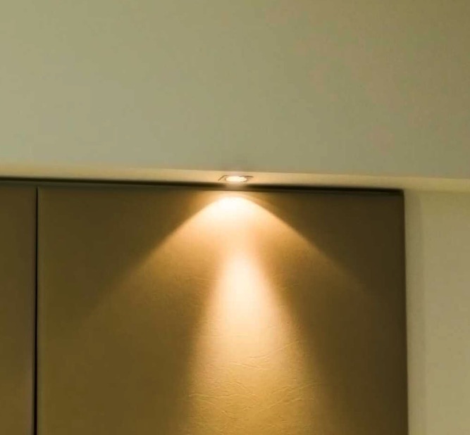 Spot lighting above the leather headboard