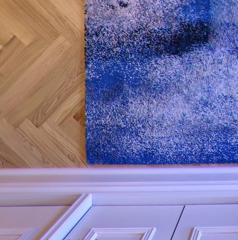 Abstract painting above herringbone parquet