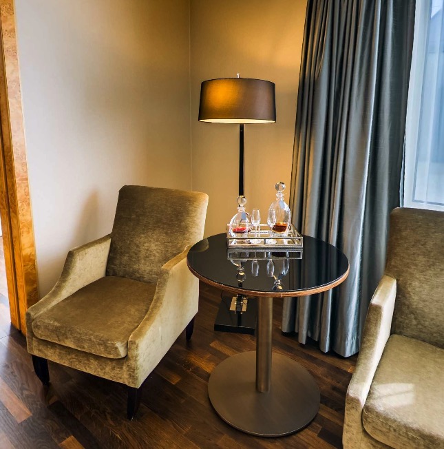 Seating nook with velvet armchairs and crystal decanters