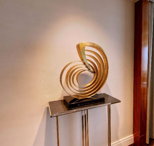Gold spiral sculpture on a console table